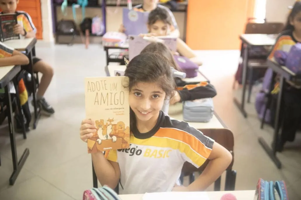 Aluna do Fundamental I do Colégio Basic segurando um livro