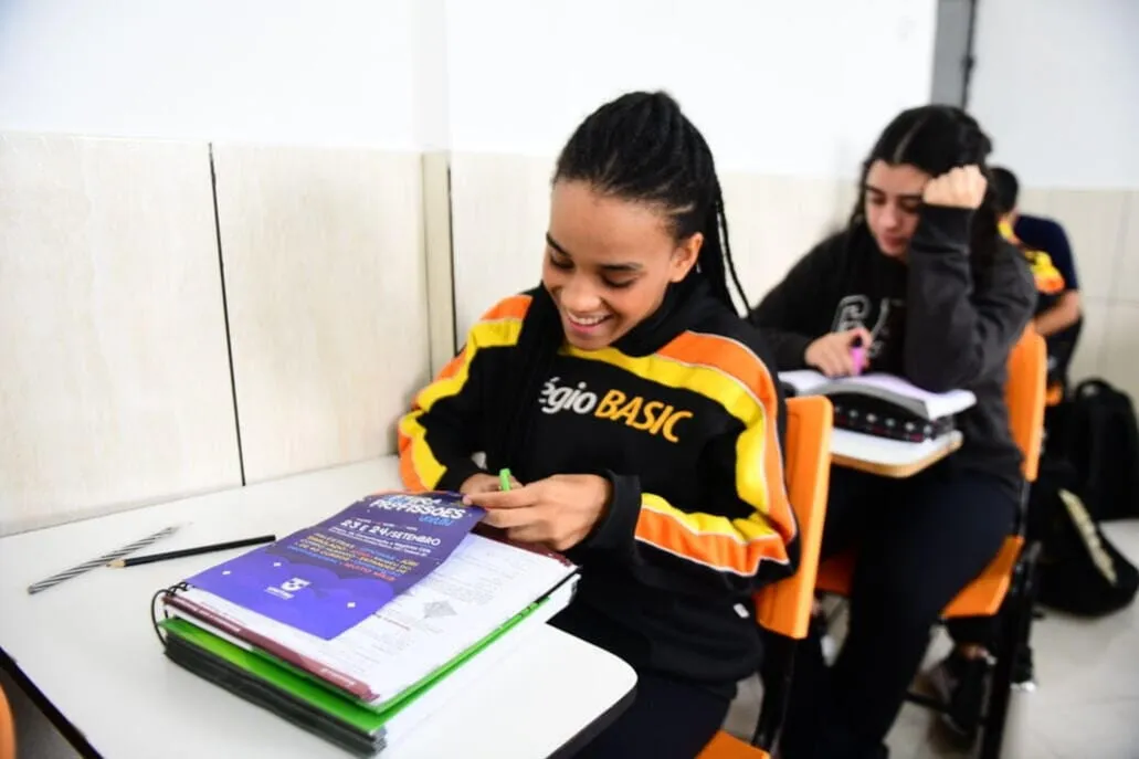 Aluna do Ensino Médio do Colégio Basic com o material do Sistema Farias Brito