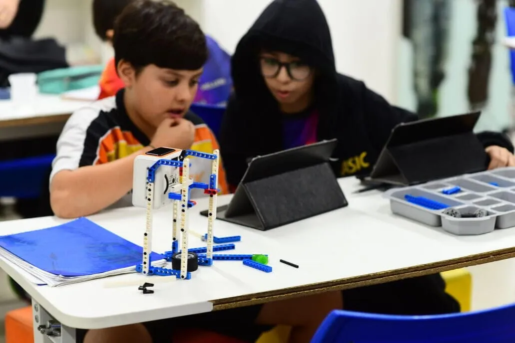 Alunos do Colégio Basic montando um robô com tablets na aula de robótica