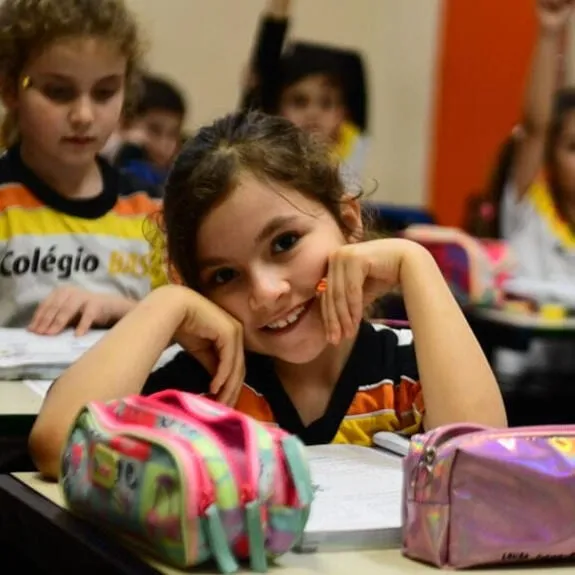 Aluna da Educação Infantil sorrindo na sala de aula