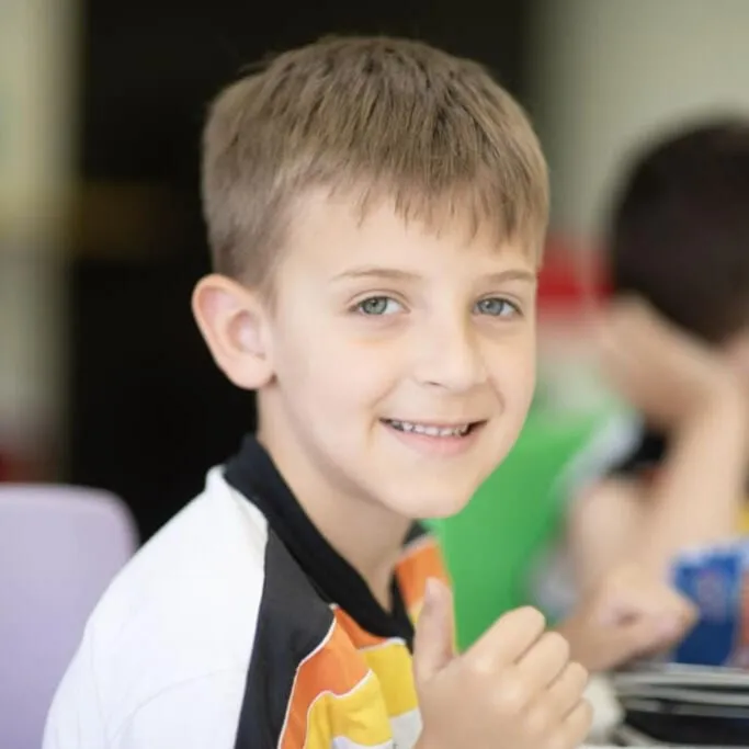 Aluno do Ensino Fundamental I sorrindo na sala de aula