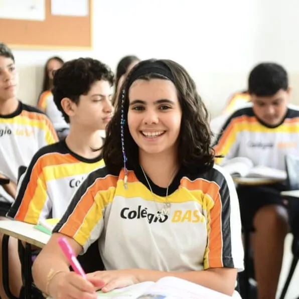Aluna do Ensino Fundamental II sorrindo com o uniforme do Colégio Basic