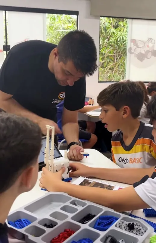 Professor orientando alunos, robótica no Colégio Basic